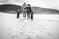 Happy young family is walking on sandy beach and ocean Royalty Free Stock Photo